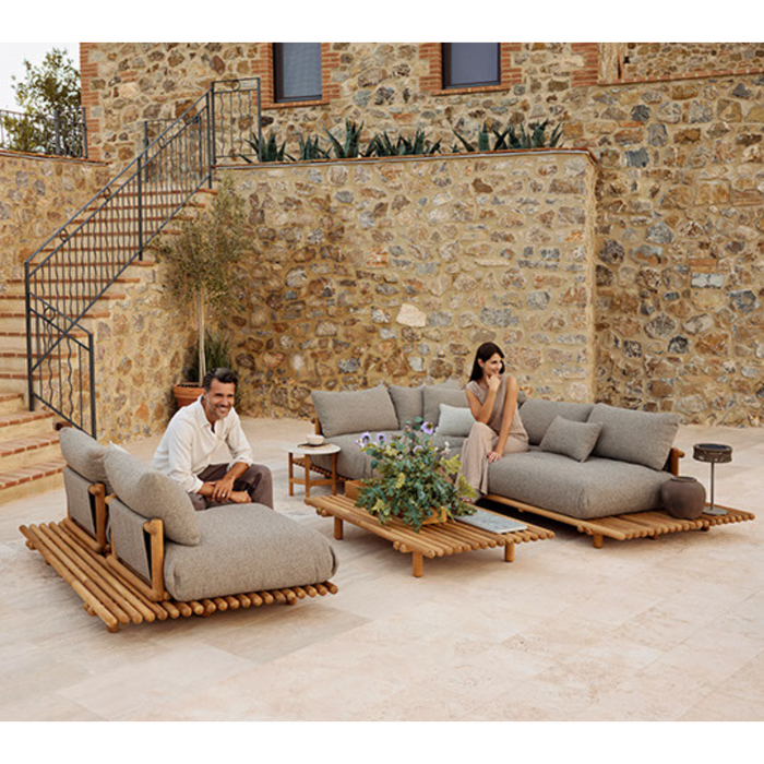 sticks platform corner sofa large Teak Light brown Cane-line Rise cushion in a patio with a woman enjoying the sofa lifestyle