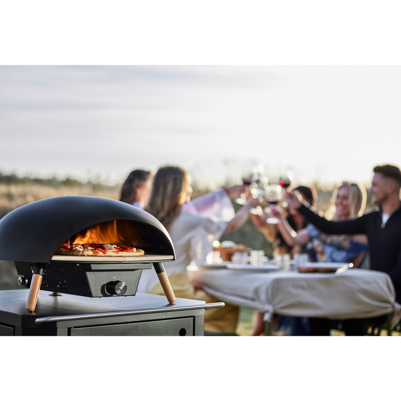 Le Feu Turtle Black Gas Powered Pizza Oven with pizza lifestyle