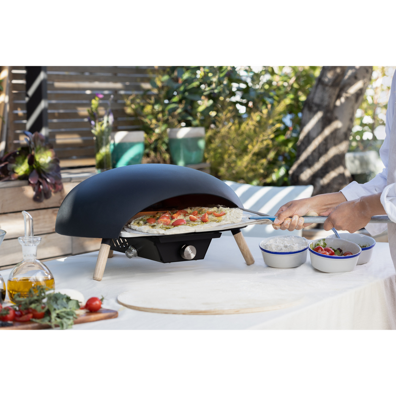 Le Feu Turtle Black Gas Powered Pizza Oven with pizza outdoor lifestyle