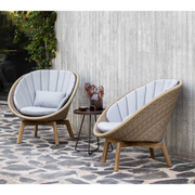 Cane line Peacock lounge chair Natural, large flat Cane-line Weave w/teak and Light grey, Cane-line Natté cushion in a patio lifestyle
