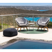Cane line Peacock lounge chair Grey/light grey, small flat Cane-line Weave w/teak and Light grey, Cane-line Focus cushion in a pool lifestyle