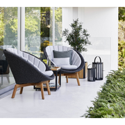 Cane line Peacock lounge chair Dark grey, medium flat Cane-line Soft Rope w/teak and Light grey, Cane-line Natté cushion in a patio lifestyle