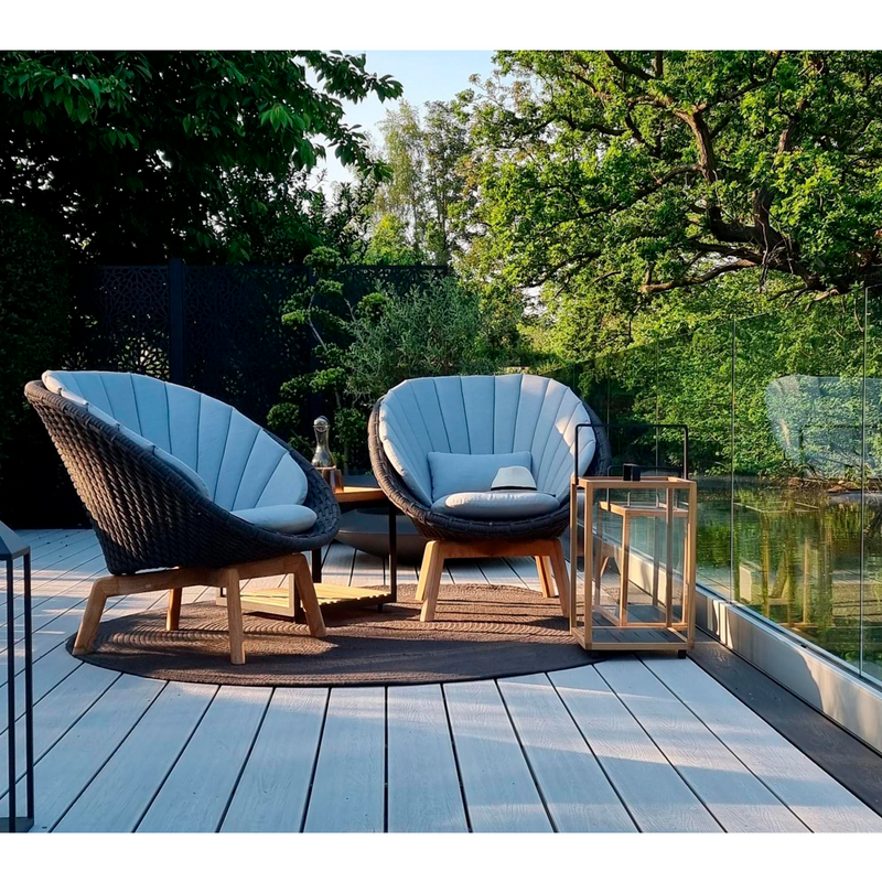 Cane line Peacock lounge chair Dark grey, medium flat Cane-line Soft Rope w/teak and Light grey, Cane-line Natté cushion in a patio lifestyle