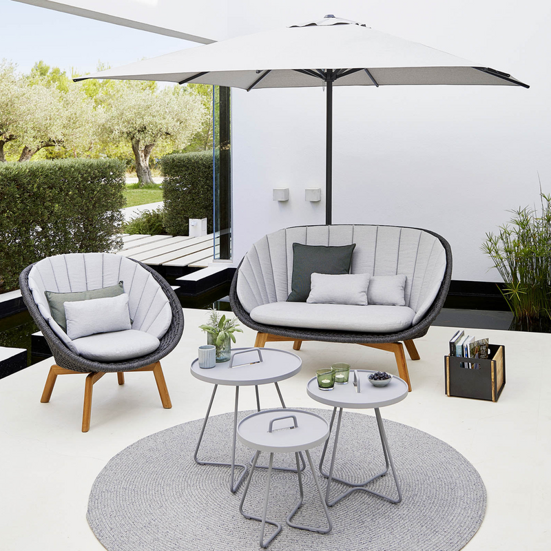 Cane line Peacock lounge chair Dark grey, medium flat Cane-line Soft Rope w/teak and Light grey, Cane-line Focus cushion in a patio with outdoor furniture lifestyle