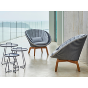 Cane line Peacock lounge chair Grey/light grey, small flat Cane-line Weave w/teak and Light grey, Cane-line Natté cushion in a patio lifestyle
