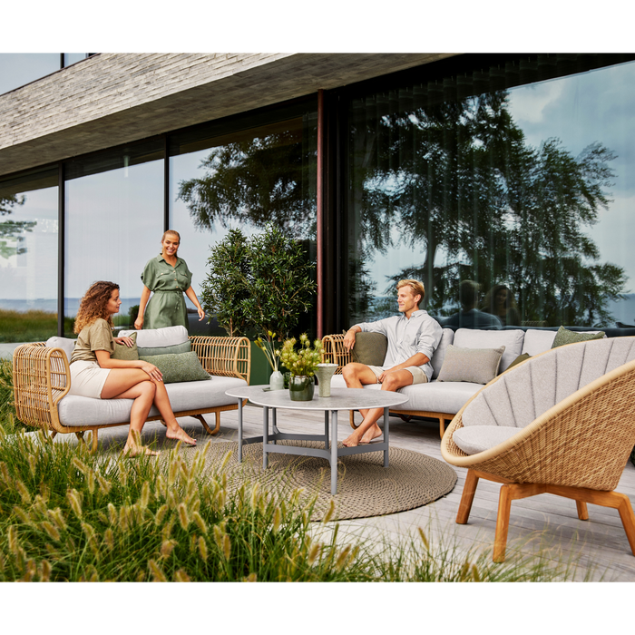 Nest outdoor 3 seater Sofa White Natte cushion in a patio with people enjoying the outdoor furniture lifestyle