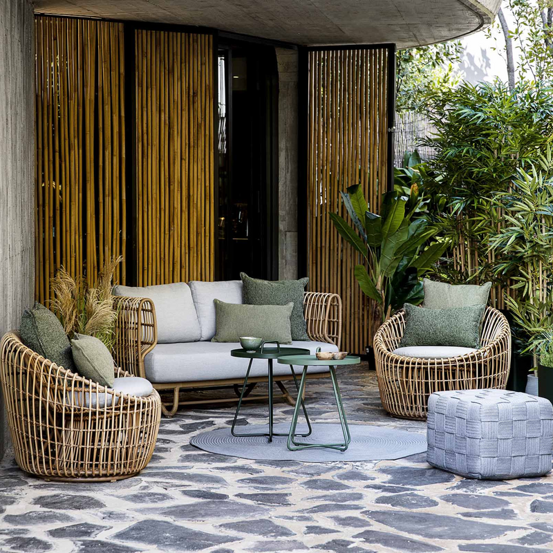 Cane line Nest outdoor round chair Natural Light Grey Natte cushion in a patio with outdoor furniture lifestyle