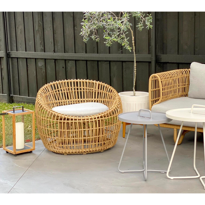 Cane line Nest outdoor round chair Natural Light Grey Natte cushion in a patio with outdoor furniture lifestyle